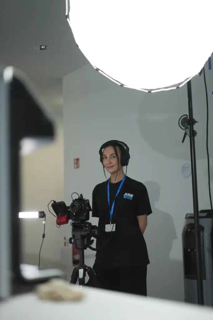 Frau mit Kopfhörern lächelt vor professionellem Video-Equipment in einem Medienstudio in Paderborn.